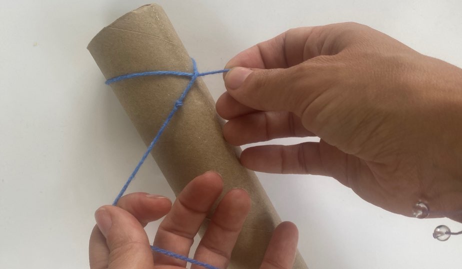 tied string or yarn around a paper towel craft fishing pole